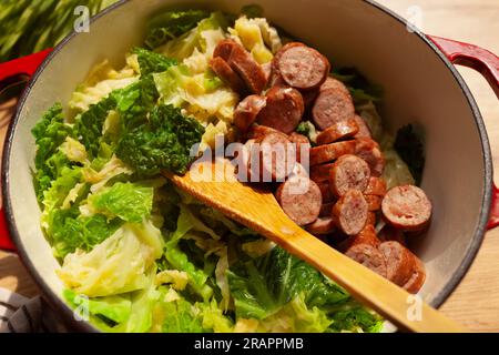 Chou frisé cuit et ragoût de saucisse dans la gousse rouge vue de dessus Banque D'Images