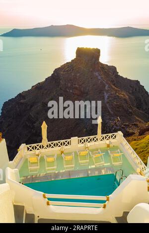 Piscine de villégiature de l'hôtel haut de gamme sur le bord de la falaise Caldera à Imerovigli,.Skaros rock et l'île de Therasia en arrière-plan, Grèce Banque D'Images