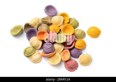 Tas de pâtes crues italiennes colorées Orecchiette Arcobaleno isolé sur fond blanc gros plan Banque D'Images