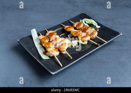 Restaurant de sushi, vue sur un plat japonais grillé, EBI Kushi. Banque D'Images