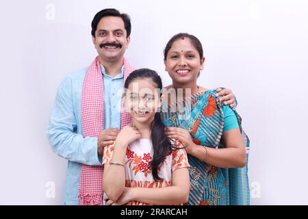 Famille indienne rurale heureuse de villageois d'un père, mère et fille debout ensemble sur un fond blanc. Banque D'Images