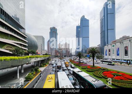 Zone de Xujiahui, circulation très fréquentée et passerelle surélevée avec le bâtiment Metro City en forme de sphère de verre et gratte-ciel Grand Gateway en journée Banque D'Images