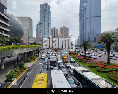 Zone de Xujiahui, circulation très fréquentée et passerelle surélevée avec le bâtiment Metro City en forme de sphère de verre et gratte-ciel Grand Gateway en journée Banque D'Images