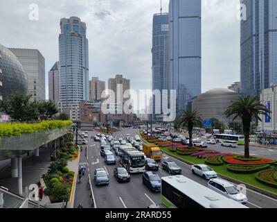 Zone de Xujiahui, circulation très fréquentée et passerelle surélevée avec le bâtiment Metro City en forme de sphère de verre et gratte-ciel Grand Gateway en journée Banque D'Images