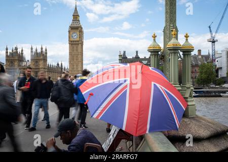 Londres, Royaume-Uni. 5 juillet 2023. Les touristes passent devant un parapluie Union Jack sur Westminster Bridge. L'Organisation de coopération et de développement économiques (OCDE) a indiqué que le Royaume-Uni est aujourd'hui le seul pays du G7 à faire face à une inflation croissante. L'inflation au Royaume-Uni a augmenté à 7,9% en mai, contre 7,8% en avril, tandis que parmi les pays du G7, le taux a glissé à 4,6%, contre 5,4%. Crédit : Stephen Chung / Alamy Live News Banque D'Images