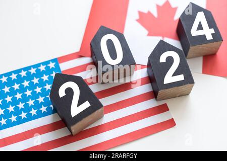 Élection présidentielle américaine 2024. Cubes en bois avec les lettres 2024 sur le fond du drapeau américain. Politique et vote conceptuel Banque D'Images