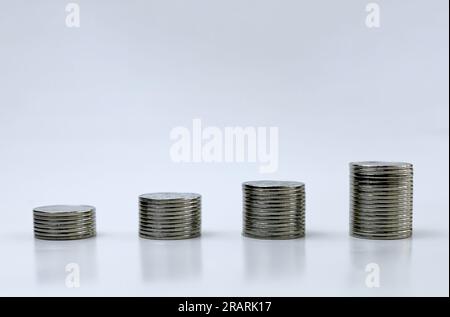 Quatre piles de pièces de monnaie avec fond blanc. concept de planification d'entreprise et diagramme à barres Banque D'Images