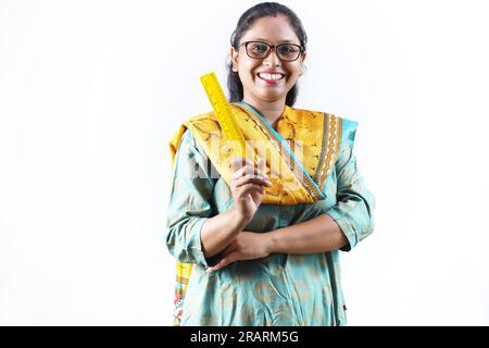 Professeur en tenue indienne. Portrait de Happy Indian Teacher tenant une échelle de mesure en main et des spécifications de port. Expressions diverses. Banque D'Images