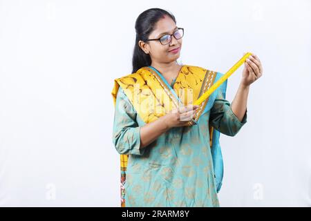 Professeur en tenue indienne. Portrait de Happy Indian Teacher tenant une échelle de mesure en main et des spécifications de port. Expressions diverses. Banque D'Images