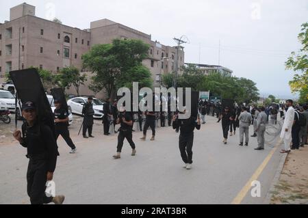 Islamabad, Pakistan. 04 juillet 2023. Le personnel de sécurité muni de boucliers balistiques escorte un véhicule transportant l'ancien Premier ministre pakistanais Imran Khan, alors qu'il arrive devant le tribunal. Khan a régulièrement vu des collaborateurs proches et des membres de son parti Pakistan Tehreek-e-Insaf (PTI) quitter son camp, au milieu d'une crise politique qui s'aggrave depuis plus d'un an. (Photo de Raja Imran Bahadar/Pacific Press) crédit : Pacific Press Media production Corp./Alamy Live News Banque D'Images