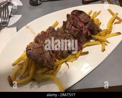 steak de veau grillé avec frites sur une assiette en céramique blanche Banque D'Images