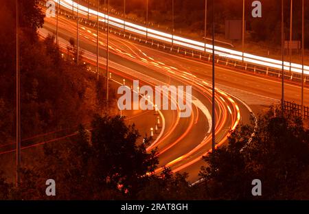 L'empennage et les phares de la voiture s'estompent la nuit Banque D'Images