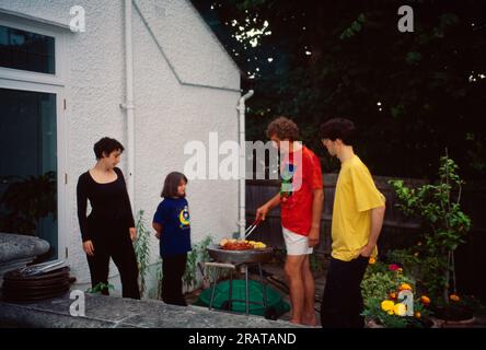 Famille ayant barbecue à Garden Surrey Angleterre Banque D'Images