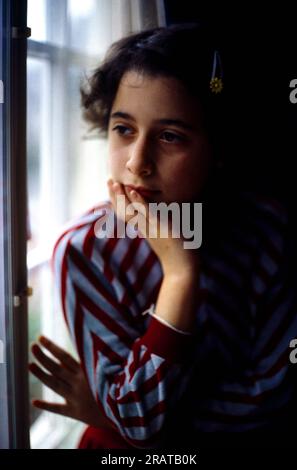 Fille de 12 ans regardant par la fenêtre l'Angleterre réfléchie Banque D'Images