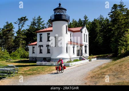 WA24510-00.. WASHINGTON - touriste à vélo au phare d'Admiralty Head dans le parc historique de Fort Casey, Whidby Island. Banque D'Images