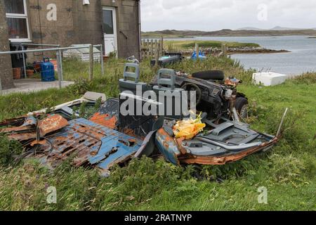 Reliques rouillées d'une vieille voiture épave dans le jardin près de la mer, Hébrides extérieures, îles occidentales, Écosse, Royaume-Uni, Grande-Bretagne Banque D'Images