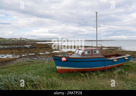 Bateau à cabine en bois multicolore sur les rives de la côte est de Berneray, North Uist, Hébrides extérieures, Western Isles, Écosse, Royaume-Uni Banque D'Images