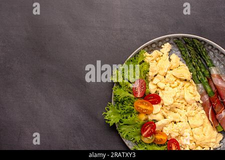 Photographie de nourriture vierge de petit déjeuner, oeuf brouillé, asperges frites, prosciutto, tomate, feuille, laitue, brunch, fond, repas, alimentation Banque D'Images