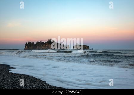 WA23485-00...WASHINGTON - James Island vue de Rialto Beach au lever du soleil sur la côte Pacifique dans le parc national olympique. Banque D'Images