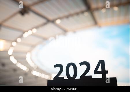 Silhouette du signe '2024' inspire alors que commence l'année sportive, menant aux Jeux d'été à Paris. Stade moderne en arrière-plan. Banque D'Images