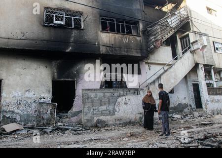 Djénine, Palestine. 05 juillet 2023. Des Palestiniens inspectent une maison incendiée et détruite dans le camp de réfugiés de Djénine, près de la ville de Djénine, dans le nord de la Cisjordanie. Le retrait des troupes du camp a mis fin à une intense opération de deux jours qui a tué au moins 13 Palestiniens, chassé des milliers de personnes de leurs maisons et laissé une grande partie de dégâts dans son sillage. Un soldat israélien a également été tué. Crédit : SOPA Images Limited/Alamy Live News Banque D'Images