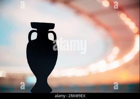 Silhouette du Trophée européen de football rayonnant dans la splendeur du soir. Photo pour football Europe Tournament. Modifiez l'espace pour votre montage Banque D'Images