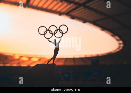 PARIS, FRANCE, 7 JUILLET 2023 : une force inspirante : la statue de l'athlète féminine élève le cercle olympique au stade olympique moderne. Photo de sport pour Paris 20 Banque D'Images