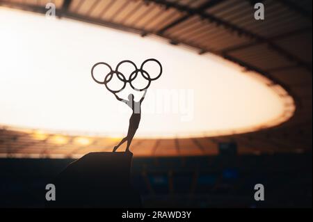 PARIS, FRANCE, 7 JUILLET 2023 : une force inspirante : la statue de l'athlète féminine élève le cercle olympique au stade olympique moderne. Photo de sport pour Paris 20 Banque D'Images