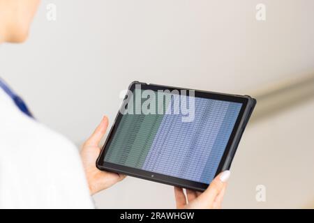 Femme caucasienne médecin portant l'uniforme médical utilisant le comprimé à l'hôpital. Services hospitaliers, de communication, de médecine et de soins de santé, inchangés. Banque D'Images