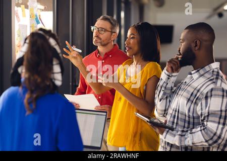 Divers gens d'affaires ayant des réunions, brainstorming et utilisant un ordinateur portable au bureau. Affaires occasionnelles, travail d'équipe, communication et travail, inchangés. Banque D'Images