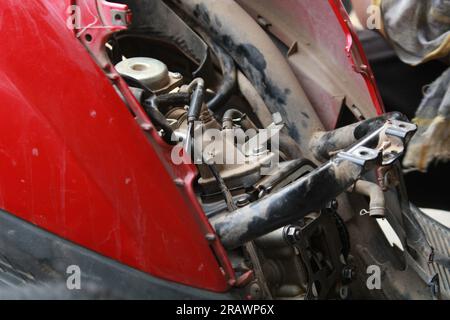 Mécanicien répare un motercycle. Un homme travaille comme mécanicien dans un atelier de réparation de motos local. Odisha, Inde. Banque D'Images