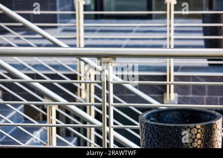 balustrade moderne en acier inoxydable sur un escalier carrelé de céramique grise Banque D'Images