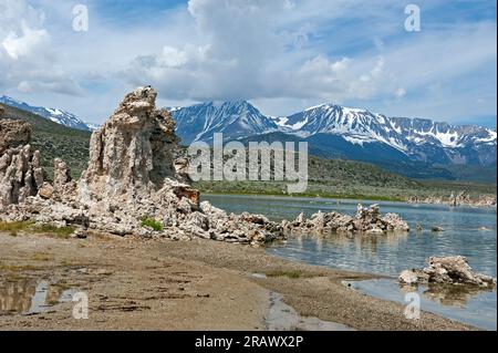 Tufas et l'eau en retrait avec les montagnes de la Sierra Nevada en arrière-plan à Mono Lake, Californie, États-Unis Banque D'Images