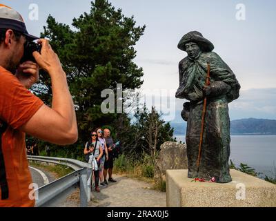 6 juin 2023, Finisterra, Espagne : un randonneur prend une photo de la sculpture d'un pèlerin asiatique. Le Camino de Santiago (le chemin de St. James) est un vaste réseau d'anciennes routes de pèlerins qui s'étendent à travers l'Europe et se rejoignent sur la tombe de Saint James (Santiago en espagnol) à Santiago de Compostelle, Espagne. Finisterre était à la fois la fin du monde connu jusqu'à ce que Colomb change les choses et la destination finale de nombreux pèlerins qui ont fait le voyage à Santiago au cours des siècles passés. Les pèlerins des siècles passés ont également continué vers le nord jusqu'au Santuario de Nuestra SeÃ±Ora Banque D'Images