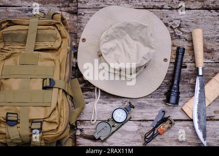 Sac à dos couteau avec équipement pour la survie dans la forêt sur le vieux fond en bois Banque D'Images