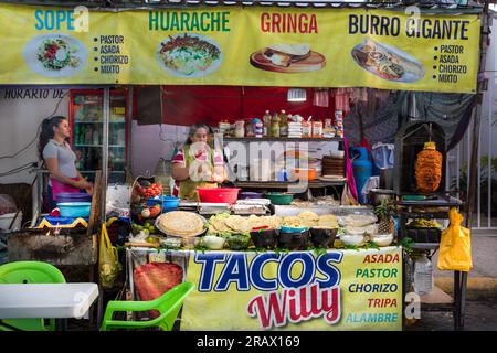 Femmes préparant de la nourriture dans un stand de tacos en plein air à Bucerias, au Mexique Banque D'Images