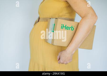 12.16.22, USA, Miami: Une femme enceinte a reçu un paquet d'iherb. Vitamines et minéraux pour une grossesse saine à l'iherbe Banque D'Images
