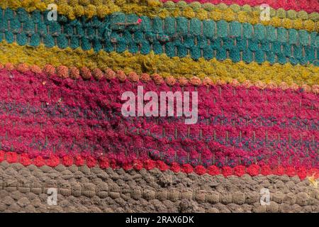 un vieux tapis rayé multicolore comme arrière-plan à la grand-mère dans le village Banque D'Images