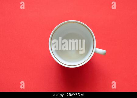 vieille tasse avec pois rouges sur fond rouge gros plan Banque D'Images