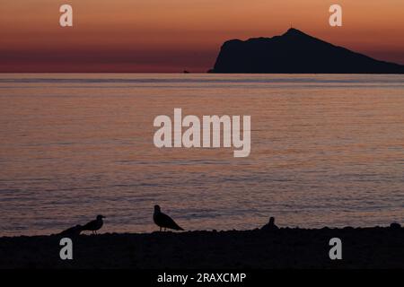 Coucher de soleil de Calpe avec silhouette de la Sierra Helada de Benidorm Banque D'Images