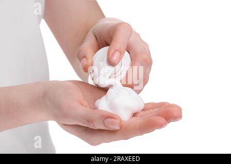 Femme appliquant la mousse nettoyante sur la main sur fond blanc, closeup Banque D'Images