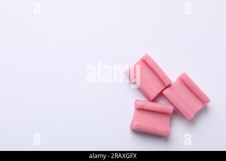 Chewing-gums roses savoureux sur fond blanc, pose plate. Espace pour le texte Banque D'Images