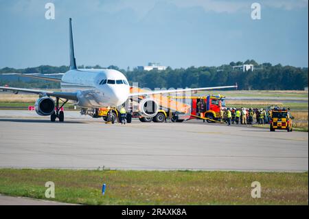 Hambourg, Allemagne. 06 juillet 2023. Des camions de pompiers et du personnel d'urgence se tiennent à côté de l'avion stationné sur le terrain d'aviation. En raison d'un poêle à fumer, un avion en route pour Istanbul a atterri à Hambourg peu après le décollage. Un porte-parole de Turkish Airlines a confirmé jeudi matin à Deutsche presse-Agentur que l'Airbus A 321 devait faire demi-tour et atterrir à Hambourg en raison d'un "problème technique". Crédit : Jonas Walzberg/dpa/Alamy Live News Banque D'Images