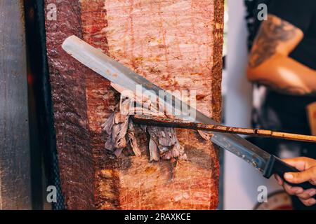 faites cuire le kebab sur une broche avec des tranches de viande grillées du gril dans un restaurant de restauration rapide du moyen-orient. Banque D'Images