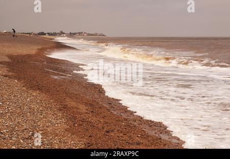 En regardant vers le nord le long de la plage à Aldeburgh à Thorpness, Suffolk. Royaume-Uni, avec la plage de galets escarpée et les vagues qui s'écrasent sur la plage Banque D'Images