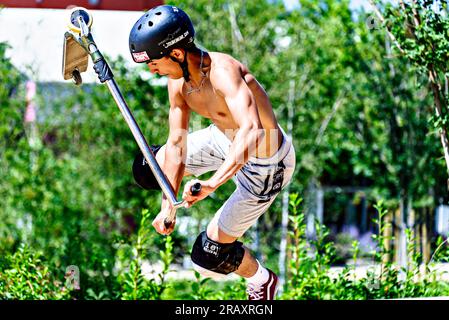 Igualada, Barcelone ; 28 juin 2023 : jeune homme pratiquant le Scootering (Freestyle Scootering) dans le nouveau Skatepark du parc central d'Igualada, Barce Banque D'Images