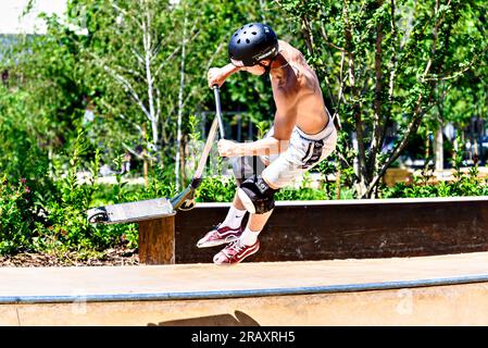 Igualada, Barcelone ; 28 juin 2023 : jeune homme pratiquant le Scootering (Freestyle Scootering) dans le nouveau Skatepark du parc central d'Igualada, Barce Banque D'Images