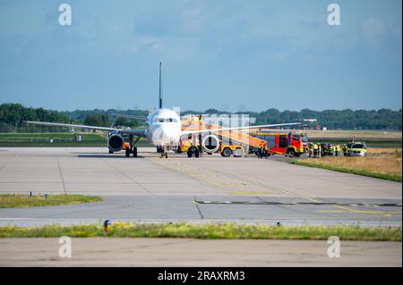 Hambourg, Allemagne. 06 juillet 2023. Des camions de pompiers et du personnel d'urgence se tiennent à côté de l'avion stationné sur le terrain d'aviation. En raison d'un poêle à fumer, un avion en route pour Istanbul a atterri à Hambourg peu après le décollage. Un porte-parole de Turkish Airlines a confirmé jeudi matin à Deutsche presse-Agentur que l'Airbus A 321 devait faire demi-tour et atterrir à Hambourg en raison d'un "problème technique". Crédit : Jonas Walzberg/dpa/Alamy Live News Banque D'Images