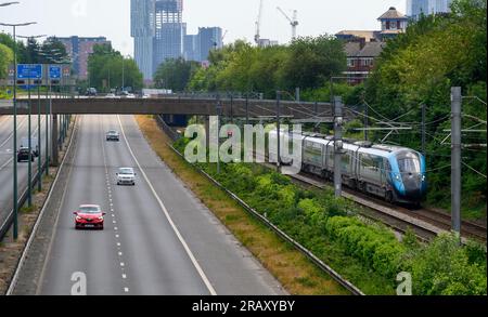 Train TransPennine Express de classe Azuma circulant sur une voie longeant une route à Salford, en Angleterre. Banque D'Images