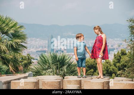 Mignons petits enfants touristes admirant la ville de Barcelone de la colline de Montjuic, Voyage avec les enfants Banque D'Images